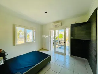 Quarto com janela e porta de vidro em apartamento.