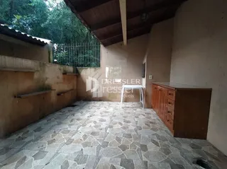Interior de um espaço com piso de cerâmica e estrutura de teto exposta.