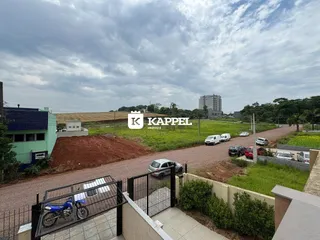Vista externa da propriedade mostrando uma estrada de terra e vegetação ao lado de um complexo de edifícios.