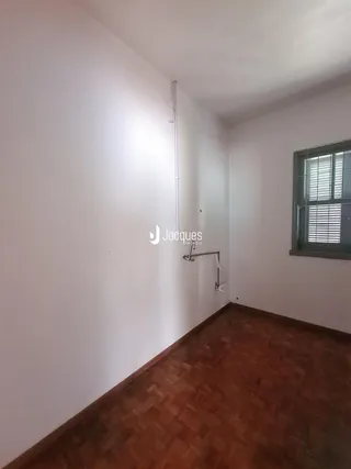 Interior de um cômodo com piso de madeira e paredes brancas.