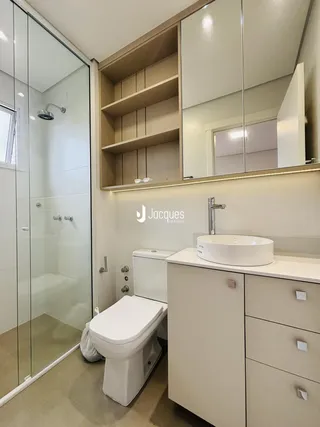 Foto de um banheiro moderno com box de vidro e bancada clara.