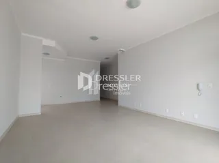 Vista interna de um corredor branco com piso liso.