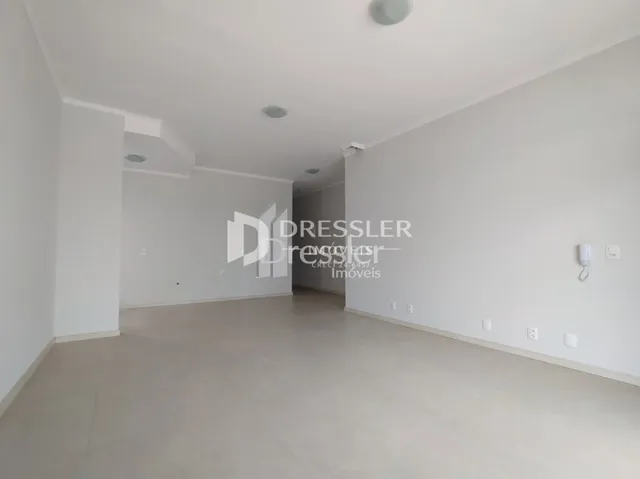 Vista interna de um corredor branco com piso liso.