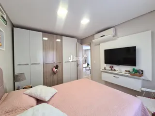 Quarto com cama grande e paredes brancas.