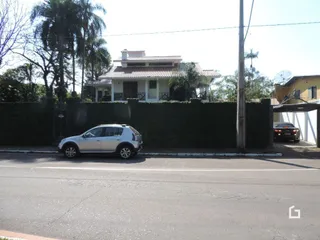 Fachada de uma residência em Lajeado, Brasil, com cerca e paisagismo.