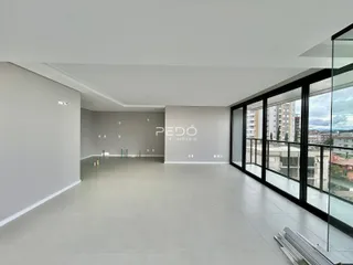 Ambiente interno moderno com piso claro e grandes janelas.