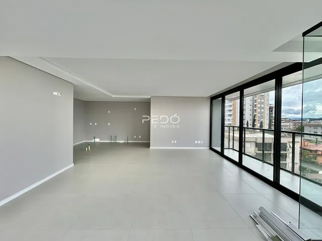 Ambiente interno moderno com piso claro e grandes janelas.