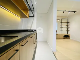 Foto de uma cozinha com armários de madeira e bancada escura.