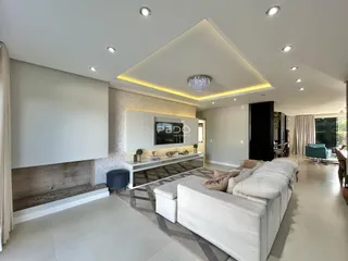 Sala de estar moderna com piso claro e sofá branco.