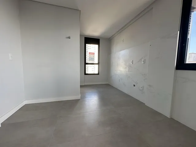 Ambiente interno com paredes brancas e piso de concreto polido.