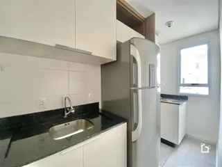 Foto da cozinha moderna com armários brancos e bancada escura.