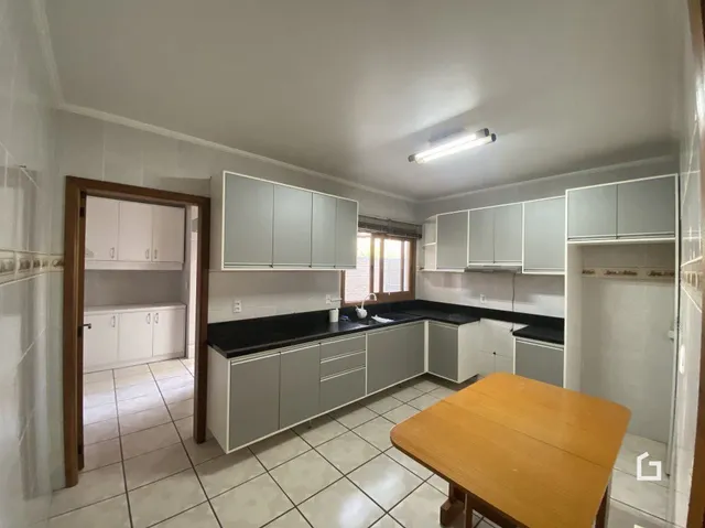 Ambiente interno com piso de cerâmica e armários brancos.