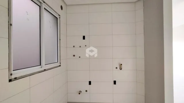 Parede interna com revestimento cerâmico e janela em um imóvel.