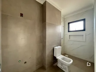 Vista de um corredor interno com um banheiro em um imóvel no Brasil.