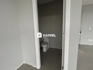 Foto de um corredor mostrando um vaso sanitário em um imóvel.
