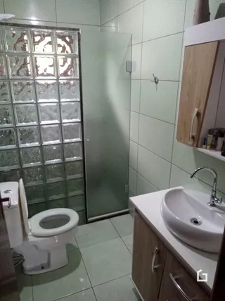 Foto de um banheiro com azulejos e um vaso sanitário.