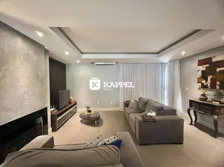 Sala de estar moderna com sofá cinza e lareira.