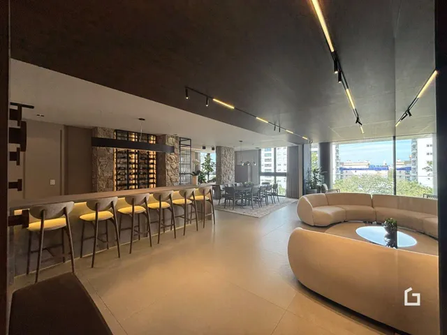 Sala de estar ampla com iluminação moderna e vista para o exterior.
