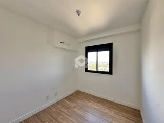 Foto de um ambiente interno com paredes brancas e piso de madeira.