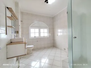 Um banheiro com piso de cerâmica e paredes brancas é mostrado na foto.
