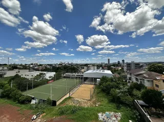 Vista aérea de uma área externa com quadras esportivas e vegetação em Lajeado.
