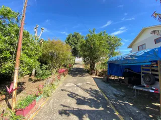 Vista externa do terreno com caminho e vegetação ao lado da propriedade.