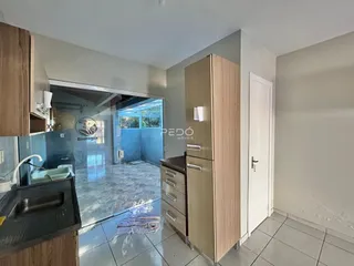 Interior de uma sala de estar com armário em madeira e piso de cerâmica.