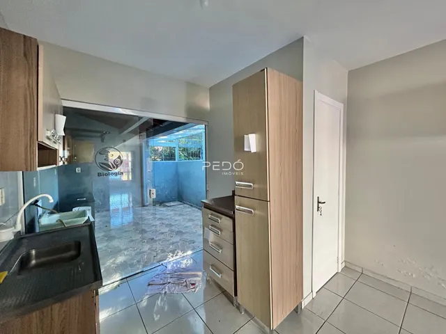 Interior de uma sala de estar com armário em madeira e piso de cerâmica.