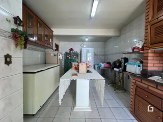 Foto de uma cozinha com armários de madeira e revestimento cerâmico.