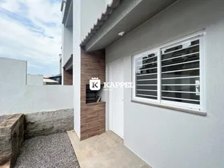 Fachada externa de uma residência branca com revestimento de madeira na parede.