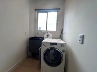 Foto de um cômodo interno com máquina de lavar e janela.