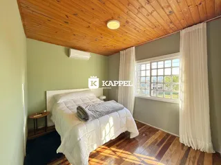 Foto de um quarto com cama de casal e piso de madeira.