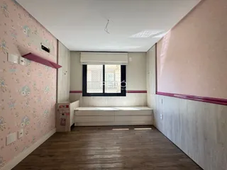 Quarto com parede decorada e piso de madeira em imóvel no Brasil.