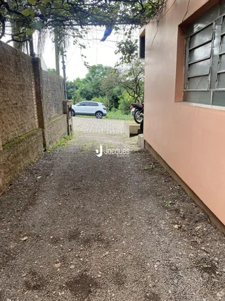 Vista da rua de acesso entre duas paredes laterais de uma propriedade em Lajeado.