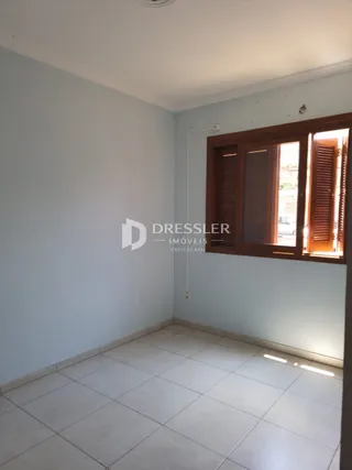 Interior de uma sala com paredes claras e piso de cerâmica.