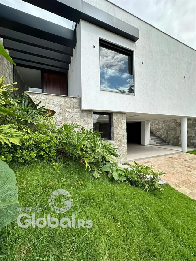 Fachada moderna de uma residência em Lajeado, Brasil, com jardim verde.