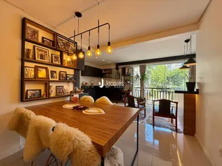 Ambiente interno de uma sala de estar com mesa de madeira e decoração rústica.