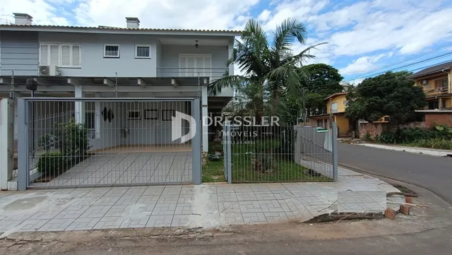 Fachada de uma residência em Lajeado, Brasil, com portão de ferro e cerca.