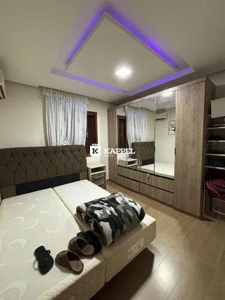 Quarto com cama e cabeceira em um ambiente com iluminação moderna.