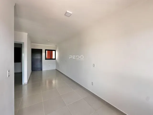 Corredor interno de uma residência com piso de cerâmica clara.