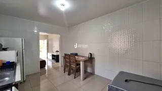 Sala de jantar com mesa de madeira e piso de cerâmica na residência.