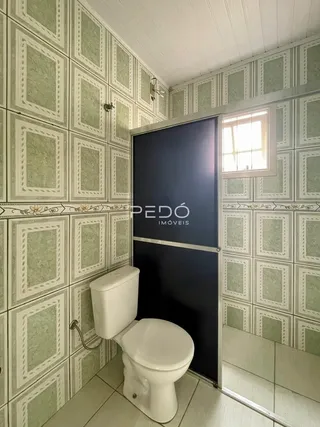 Foto de um banheiro com revestimento de azulejos e porta escura.