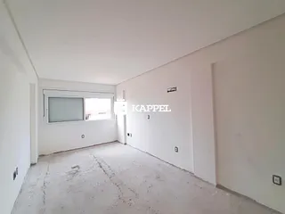 Hall de entrada com paredes brancas e piso de concreto cru.