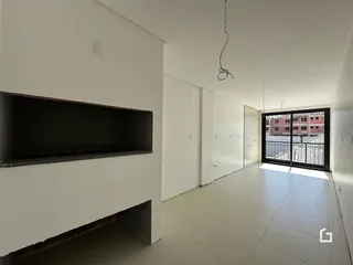 Corredor interno de um imóvel com paredes brancas e portas de madeira.