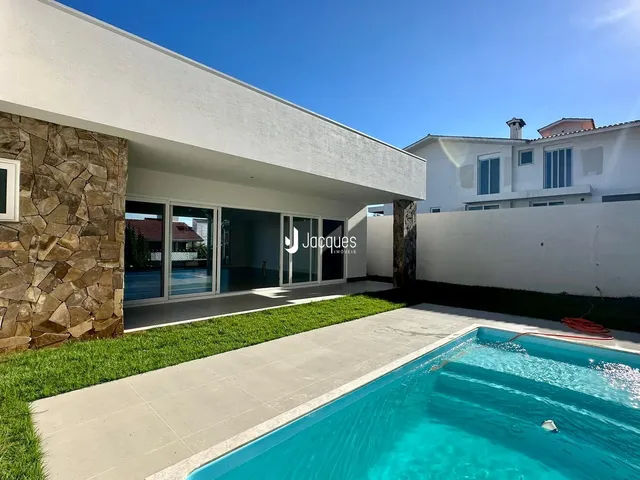 Fachada moderna de uma residência com piscina e jardim em Lajeado, Brasil.