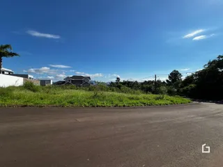 Vista externa de uma propriedade com vegetação e céu azul.