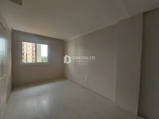 Vista interna de um cômodo com piso de madeira clara e janela.