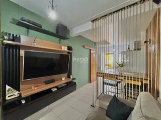 Sala de estar com televisão e sofá em um apartamento no Brasil.