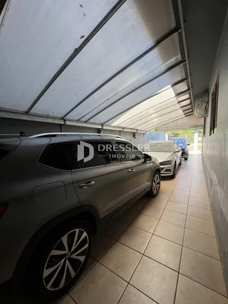 Vista de um corredor coberto com estrutura metálica em uma propriedade em Lajeado.