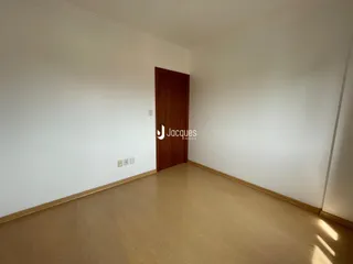 Uma sala interna com piso de madeira e porta de madeira.
